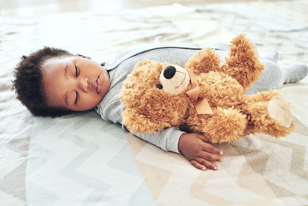 Bébé qui dort avec son doudou ours